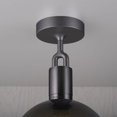 Luminária de teto em aço com formato de L bifurcado e acabamento em tom de metal escuro com cúpula fumê.