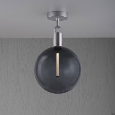 Luminária de teto em aço prateado com formato de L bifurcado e cúpula fumê.