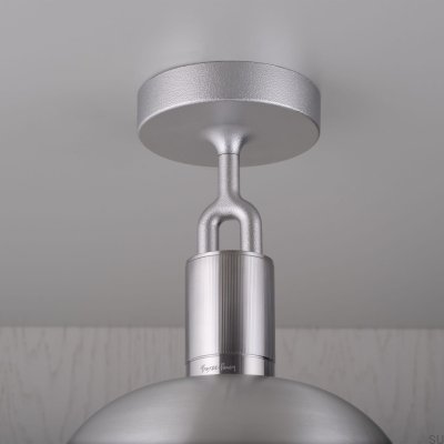 Luminária de teto em formato de L bifurcado com cobertura em aço prateado.