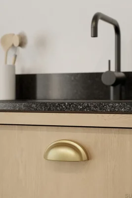 Puxador para móveis Baron 64 com revestimento metálico e acabamento em dourado escovado escuro.